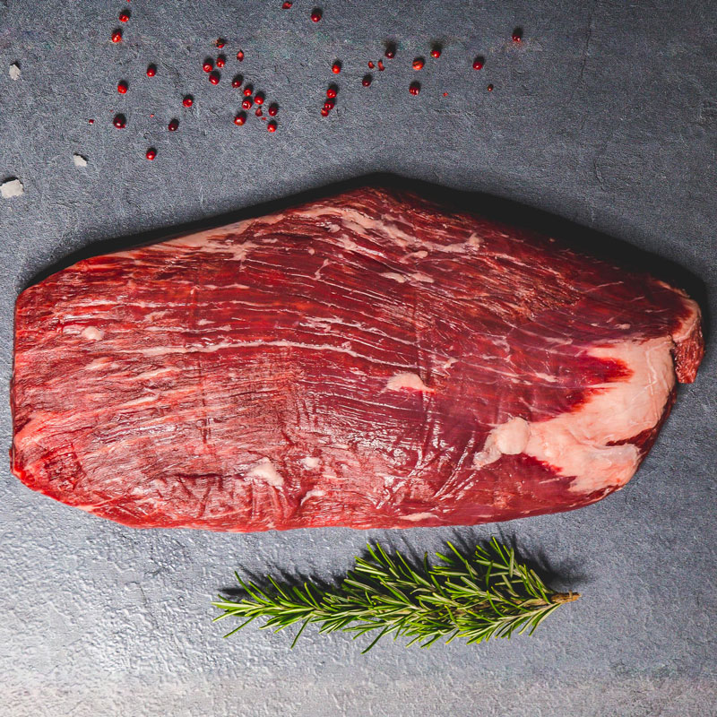 Macelleria Pezzo di carne bovina cruda con marmorizzazione evidente su sfondo scuro