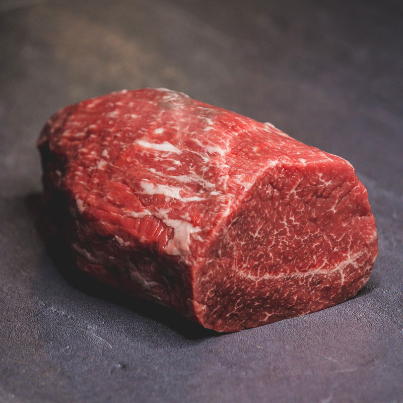 Macelleria Pezzo di carne bovina cruda con marmorizzazione evidente su sfondo scuro