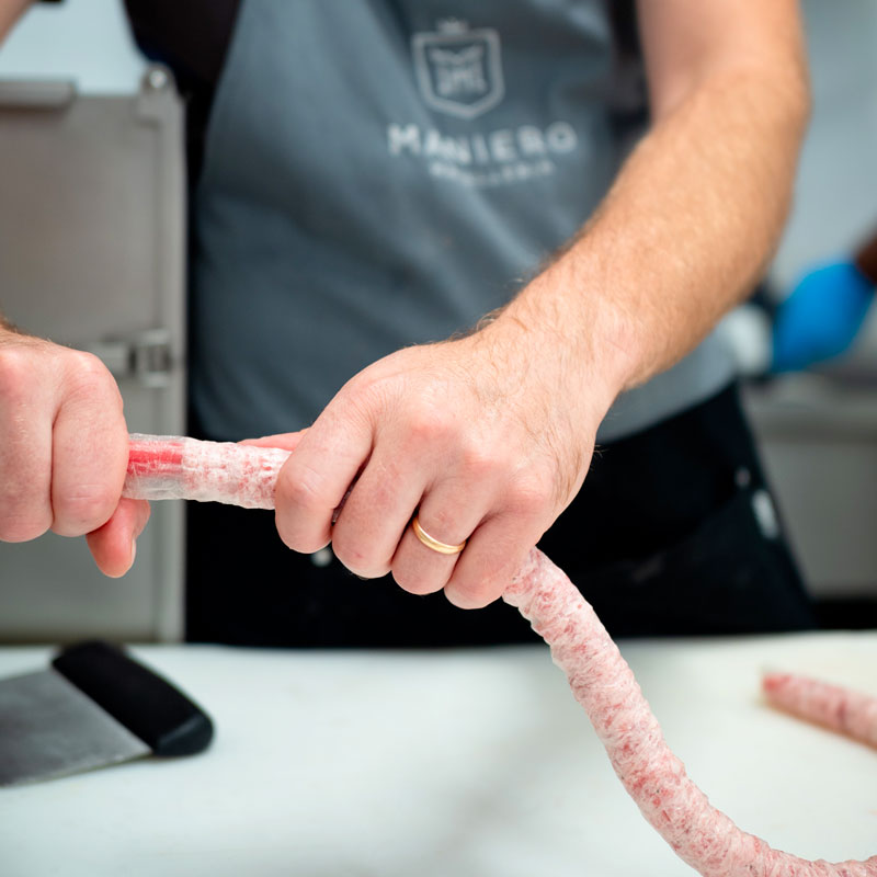 Artigianalità macellaio che prepara degli insaccati di carne