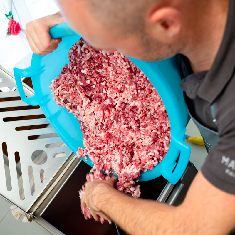 Artigianalità Macellaio che lavora la carne macinata