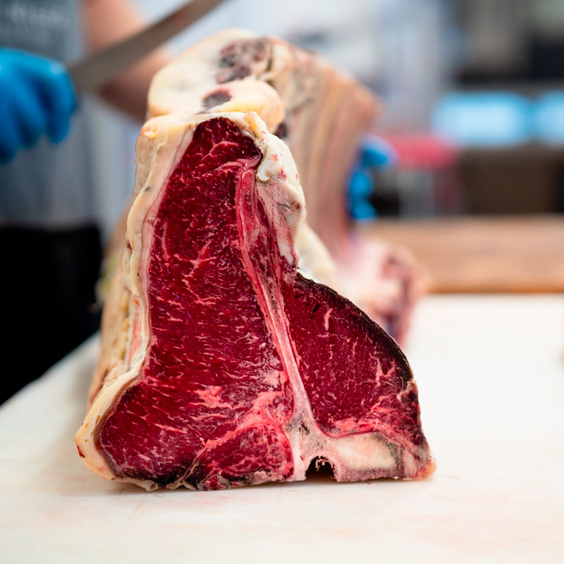Dry Aged Steak Taglio di dry aged steak su piano di lavoro di una macelleria